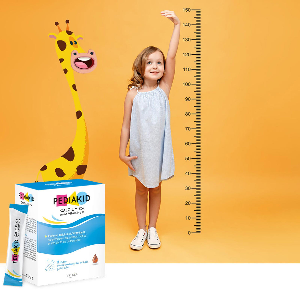 PEDIAKID Calcium C+ stickuri - fetiță care își măsoară înălțimea lângă o girafă-taliometru, alături de cutia de stickuri