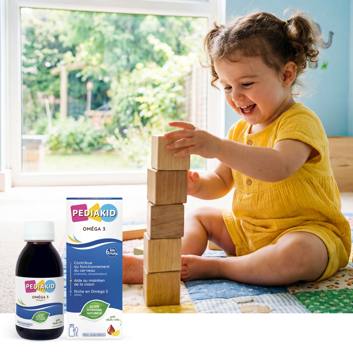 PEDIAKID Omega 3 sirop - fetiță care construiește un turn din cuburi de lemn, alături de flaconul de sirop